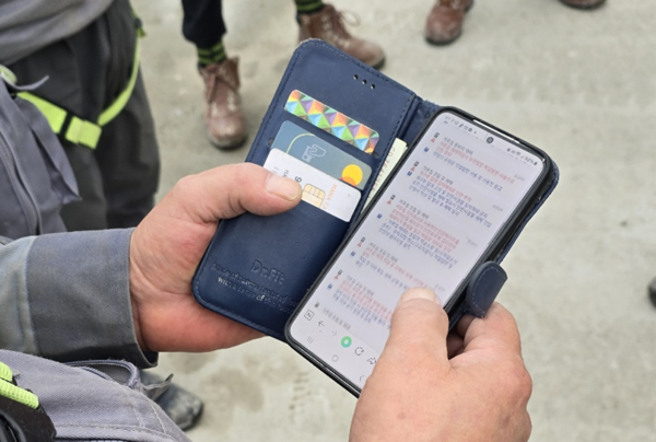 ⓒ'H-안전지갑' 앱에 공유된 작업 내용과 위험요소, 안전수칙을 확인하는 작업자 모습/ 사진-현대건설 안전보건팀 제공